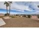 Expansive backyard featuring gravel landscaping, a tiled patio, and palm trees with scenic mountain views at 412 Lost Trail Dr, Henderson, NV 89014