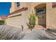 Charming home features a well-maintained stucco exterior, a two-car garage, and a welcoming front entrance with desert landscaping at 412 Lost Trail Dr, Henderson, NV 89014