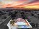 Aerial view of home with pool at sunset, mountain views at 5604 Island Breeze Ct, Las Vegas, NV 89130