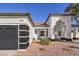 Front view of a remodeled home with a black garage door and drought-tolerant landscaping at 5604 Island Breeze Ct, Las Vegas, NV 89130