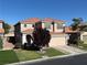 Charming two-story home with a well-manicured lawn and a beautiful tree in the front yard at 5859 Noble Stand St, Las Vegas, NV 89148