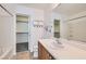 Bright bathroom featuring a vanity with sink, large mirror, and walk-in closet for ample storage at 9140 Silk Threads Ave, Las Vegas, NV 89149