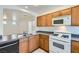 Kitchen featuring wooden cabinets, microwave, gas range, and views into the dining area at 9140 Silk Threads Ave, Las Vegas, NV 89149