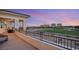 Exterior of a covered balcony with a seating area overlooking a golf course at sunset at 9145 Las Manaitas Ave # 401, Las Vegas, NV 89144
