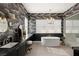 Lavish bathroom with black marble counters, a soaking tub, and modern lighting at 9145 Las Manaitas Ave # 401, Las Vegas, NV 89144