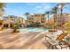 Inviting community pool area with palm trees, waterfall feature, and lounge chairs for relaxation at 9145 Las Manaitas Ave # 401, Las Vegas, NV 89144