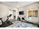 Bright exercise room with a blue patterned rug, a large window and peloton and rowing machines at 9145 Las Manaitas Ave # 401, Las Vegas, NV 89144