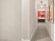 Bright hallway featuring modern artwork, neutral walls, and a glimpse into a room with colorful decor at 9145 Las Manaitas Ave # 401, Las Vegas, NV 89144