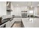 Bright kitchen features white cabinetry, stainless steel appliances, granite countertops, and a large island with pendant lighting at 9145 Las Manaitas Ave # 401, Las Vegas, NV 89144