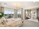 Bright main bedroom with a modern chandelier, balcony access, and adjoined office space at 9145 Las Manaitas Ave # 401, Las Vegas, NV 89144