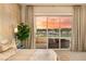Serene main bedroom features a balcony with sunset views, neutral decor, and comfortable seating area at 9145 Las Manaitas Ave # 401, Las Vegas, NV 89144