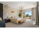 Spacious main bedroom with a balcony, modern chandelier, and a luxurious upholstered bed at 9145 Las Manaitas Ave # 401, Las Vegas, NV 89144