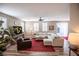 Spacious living room featuring a large sectional sofa, a red rug, and a ceiling fan at 926 Hidden Bull St, Las Vegas, NV 89178