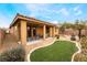 Landscaped backyard with covered patio and artificial turf at 10397 Station Creek Cir, Las Vegas, NV 89178