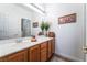 Clean bathroom with wood cabinets and large mirror at 10397 Station Creek Cir, Las Vegas, NV 89178