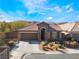 Single-story home with brown tile roof, stone accents, and landscaped front yard at 10397 Station Creek Cir, Las Vegas, NV 89178