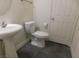 Simple bathroom with pedestal sink, toilet, and gray floor tiles at 11173 Hickory Glen St, Las Vegas, NV 89179
