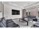 Modern lounge area with black leather sofas and a large screen TV at 1341 Villa Barolo Ave, Henderson, NV 89052