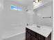 A well-lit bathroom with a white tile shower and a dark vanity at 2033 Old Field Ave, North Las Vegas, NV 89081
