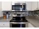Kitchen with stainless steel appliances and backsplash at 3150 Soft Breezes Dr # 2025, Las Vegas, NV 89128