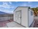 White storage shed with X-design door in backyard at 3209 Tularosa Ln, Las Vegas, NV 89122