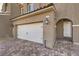 Close up of a charming two-story townhouse with a white garage door and brick driveway at 374 Yellow Finch Ln, Henderson, NV 89012