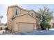 Two-story house with tan exterior, two-car garage, and landscaping at 5373 Sleeping Cat St, Las Vegas, NV 89122