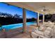 Step out to this elegant covered patio with panoramic views, overlooking a pool, lounge, and manicured landscape at 641 Saint Croix St, Henderson, NV 89012