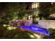 An enchanting front yard with a water feature, lush landscaping, and ambient lighting creates a welcoming entrance at 641 Saint Croix St, Henderson, NV 89012