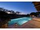 A stunning, illuminated pool at dusk offers beautiful views of a golf course and the city beyond at 641 Saint Croix St, Henderson, NV 89012