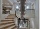A grand staircase with light-colored marble steps and glass railing ascends beneath a modern chandelier at 641 Saint Croix St, Henderson, NV 89012