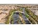 An aerial shot shows the entrance to the residential community with palm trees lining the road at 664 Orchard Course Dr, Las Vegas, NV 89148