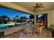 Covered patio with dining area overlooking the pool at night at 7333 Gran Paradiso Dr, Las Vegas, NV 89131