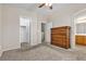 Neutral bedroom with a closet, adjacent bathroom, and classic wooden dresser against soft, carpeted floors at 9323 Leaping Deer Pl # 102, Las Vegas, NV 89178