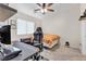 Neutral toned bedroom has a ceiling fan, desk and chair workspace, and a comfortable bed for relaxation at 9323 Leaping Deer Pl # 102, Las Vegas, NV 89178