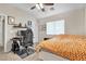 Neutral bedroom with ceiling fan, desk and orange geometric patterned comforter on a bed at 9323 Leaping Deer Pl # 102, Las Vegas, NV 89178