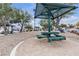 Community park area with shade structure, table, and landscaping create inviting outdoor space at 9323 Leaping Deer Pl # 102, Las Vegas, NV 89178
