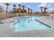 Community pool with clear blue water surrounded by palm trees at 9323 Leaping Deer Pl # 102, Las Vegas, NV 89178