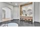 Spacious bathroom featuring dual sinks, a modern vanity, and a standalone tub complemented by sleek tiling at 9408 Players Canyon Ct, Las Vegas, NV 89144