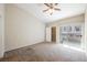 Bright bedroom featuring a ceiling fan, carpet, and a sliding door leading to the outside at 10233 King Henry Ave # 203, Las Vegas, NV 89144