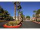 Gated community entrance with lush landscaping and mature palm trees at 10233 King Henry Ave # 203, Las Vegas, NV 89144