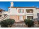 Beige two-story exterior with brown trim, balconies, windows with shutters, and well-maintained landscaping at 10233 King Henry Ave # 203, Las Vegas, NV 89144