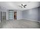 Bright, gray bedroom with wood-look floors, ceiling fan, and sliding glass closet doors at 11268 Lavandou Dr, Las Vegas, NV 89141