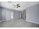 Bright, gray bedroom with wood-look floors, ceiling fan, sliding glass closet doors, and shutter style blinds at 11268 Lavandou Dr, Las Vegas, NV 89141