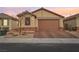 Charming single-Gathering home featuring a two-car garage, brick accents, and well-manicured landscaping at 1134 Edel Hest Ave, North Las Vegas, NV 89081