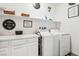 Laundry room with washer, dryer, and ample storage shelves at 1134 Edel Hest Ave, North Las Vegas, NV 89081