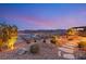 Landscaped backyard with stone pathway and lake view at dusk at 144 Stone Mesa Ct, Henderson, NV 89011