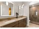 Modern bathroom with dual sinks, a large mirror, and a walk-in shower at 144 Stone Mesa Ct, Henderson, NV 89011