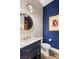 Elegant powder room with navy blue walls and gold accents at 144 Stone Mesa Ct, Henderson, NV 89011