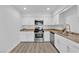 Modern kitchen with white cabinets, stainless steel appliances, and granite countertops at 2136 Chertsey Dr # A, Las Vegas, NV 89108